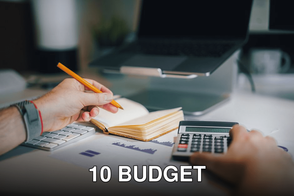 Hands using calculator and taking notes on desk with laptop, showcasing business analytics.