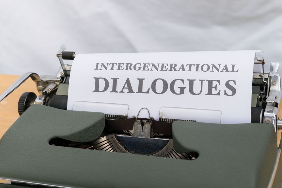 Close-up of a vintage typewriter with a sheet labeled 'Intergenerational Dialogues.'