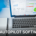 Laptop displaying charts and graphs next to a notebook, ideal for business and tech themes.