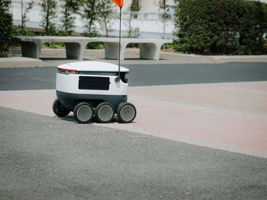 A modern autonomous delivery robot navigating an urban environment. Innovative technology for food delivery.