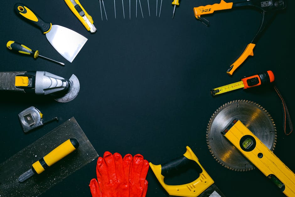 A collection of hand tools laid out on a dark surface, perfect for construction themes.