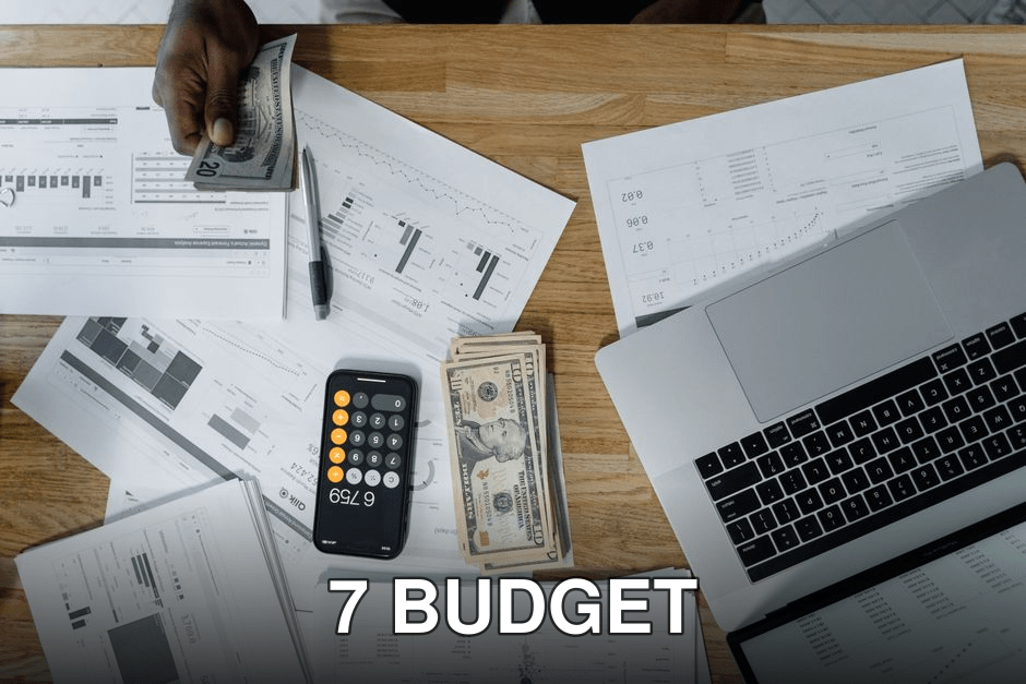 Overhead view of a busy workspace with cash, financial documents, and a laptop.