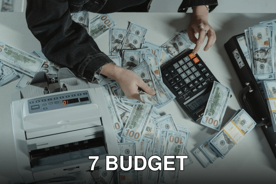 Hands counting 100 dollar bills using a calculator and money counter on a table.