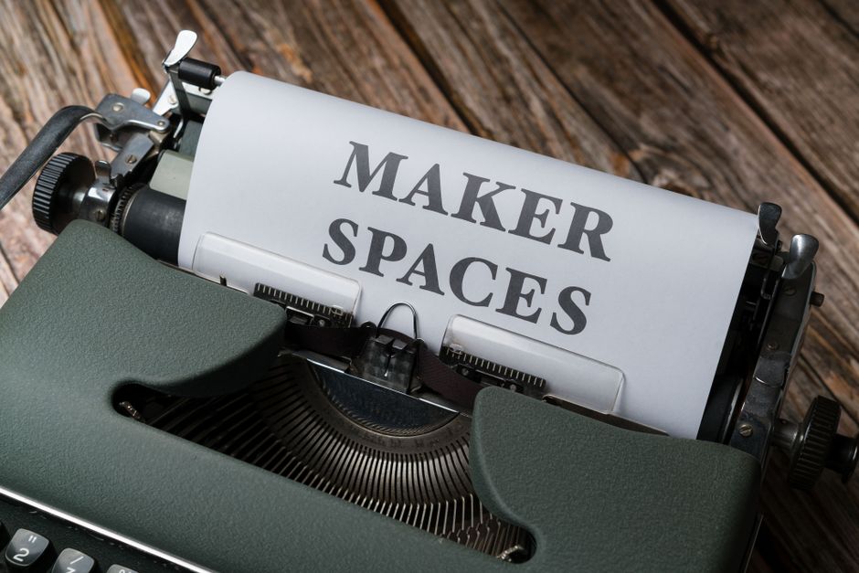 Close-up of a vintage typewriter with a paper reading 'Maker Spaces', signifying creativity and innovation.