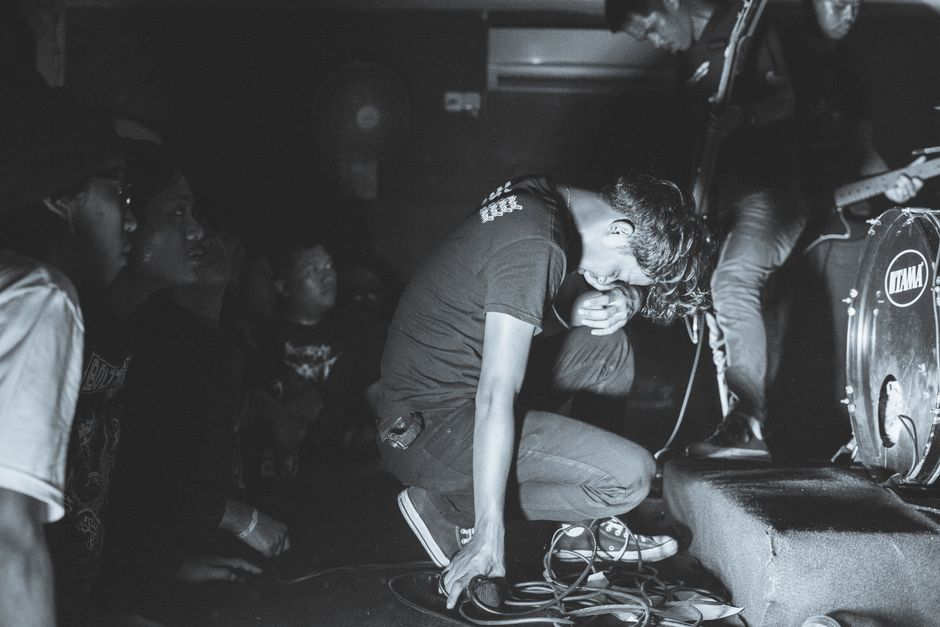 Dynamic black and white image capturing a live music concert with a singer on stage.