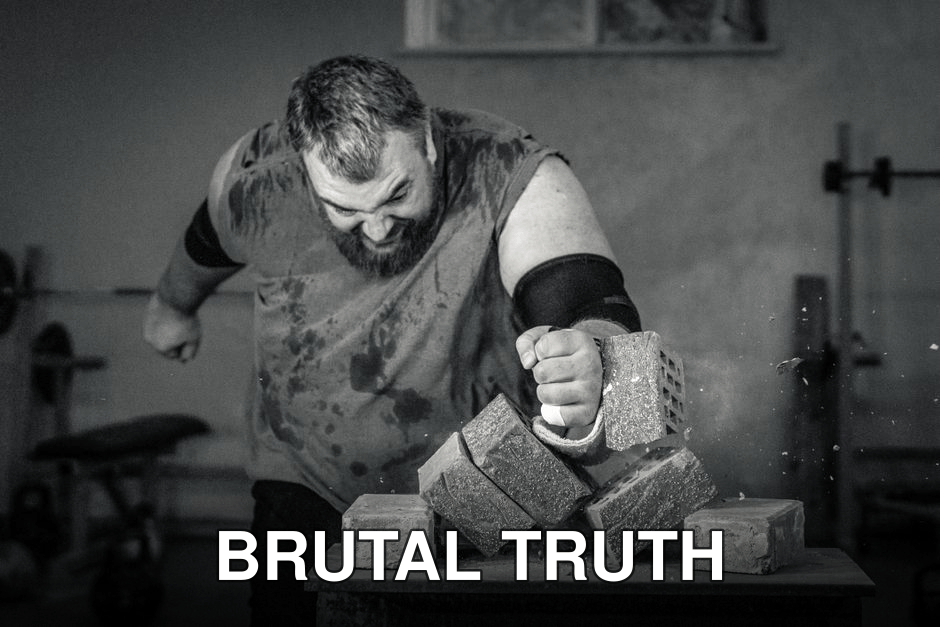 A powerful image of a strongman smashing concrete blocks with his fist, showcasing strength and determination.