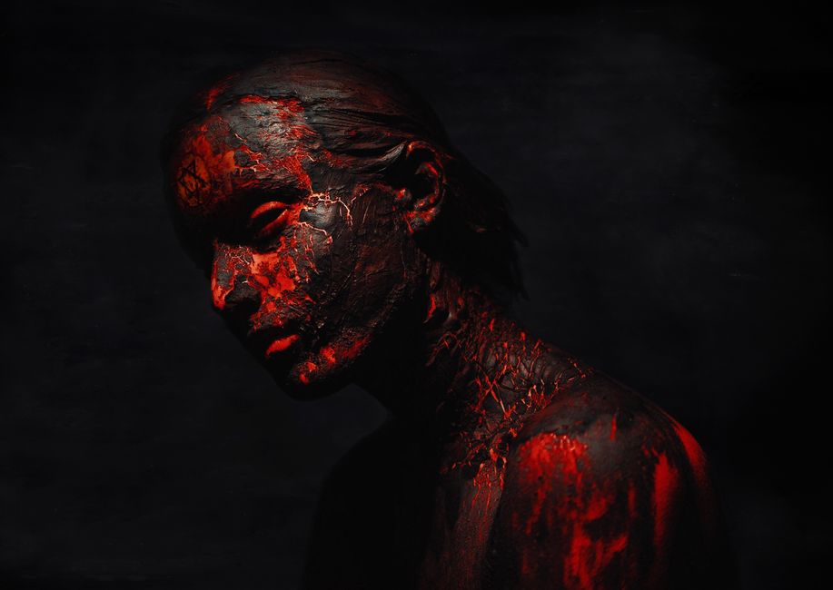 Moody artistic portrait with red and black textures on a dark background.
