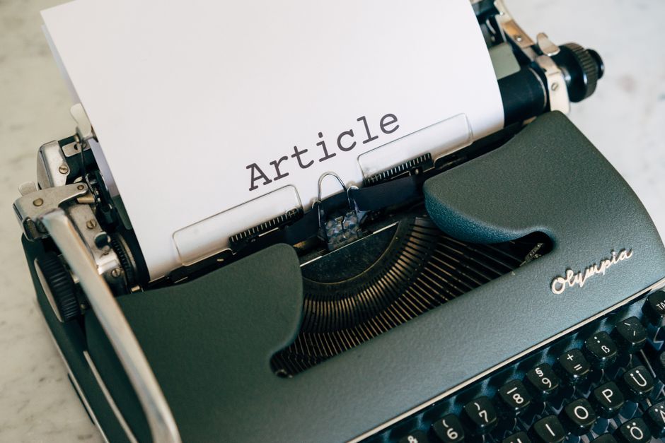 Top view of a vintage Olympia typewriter with paper titled 'Article'.