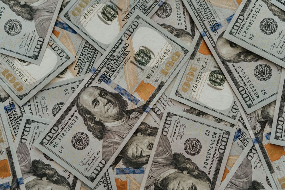 Close-up of American 100 dollar bills scattered, highlighting wealth and currency concepts.