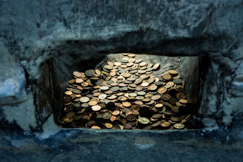 A collection of old coins nestled in a stone niche, Shipka, Bulgaria.