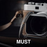 Elegant camera setup with handmade strap and lens cap, perfect for photography enthusiasts.