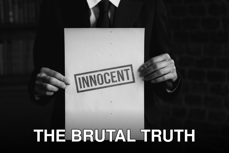 A black and white photo of a person holding a paper with 'INNOCENT' text, conveying a message of legal or moral purity.