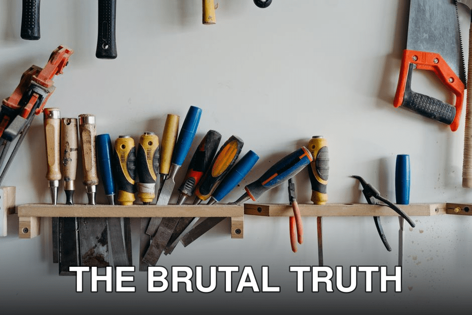 A neatly arranged collection of hand tools including chisels, saws, and screwdrivers in a workshop.
