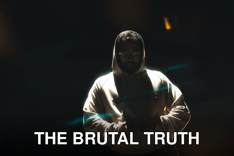 A man wearing a hoodie stands in dramatic lighting at night, hands in pockets, conveying a mysterious mood.