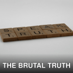 Wooden Scrabble tiles forming the phrase 'Speak Truth' on a white surface.