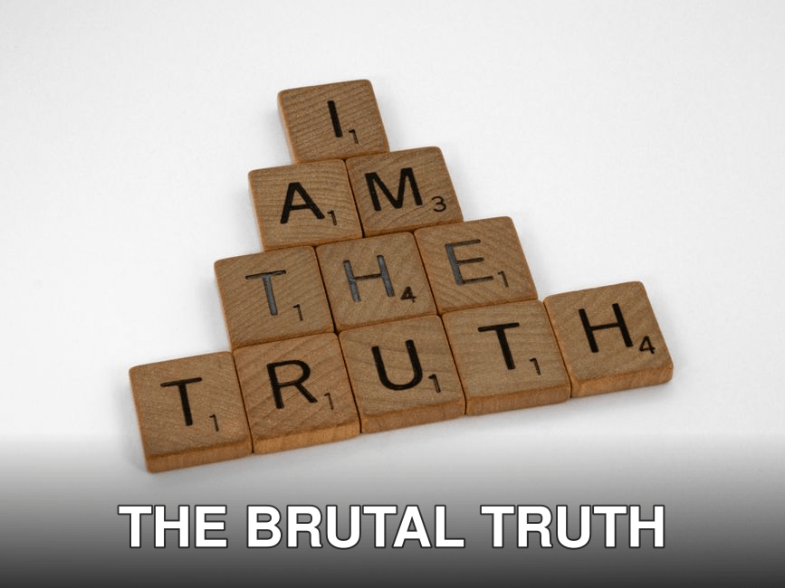 Scrabble tiles arranged on a white surface to spell 'I Am The Truth' in a pyramid shape.