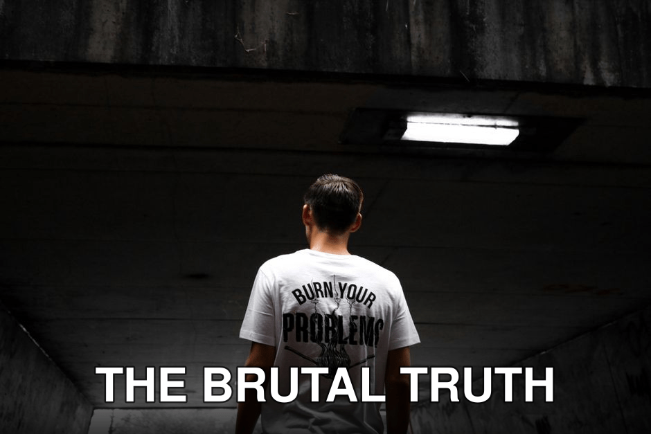A man stands in an urban tunnel wearing a t-shirt with a bold statement.