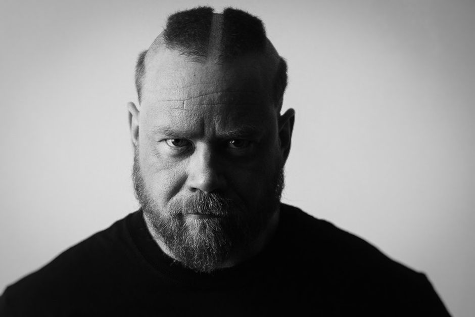 Black and white photo of a bearded man with a fierce expression, showcasing strong masculinity.