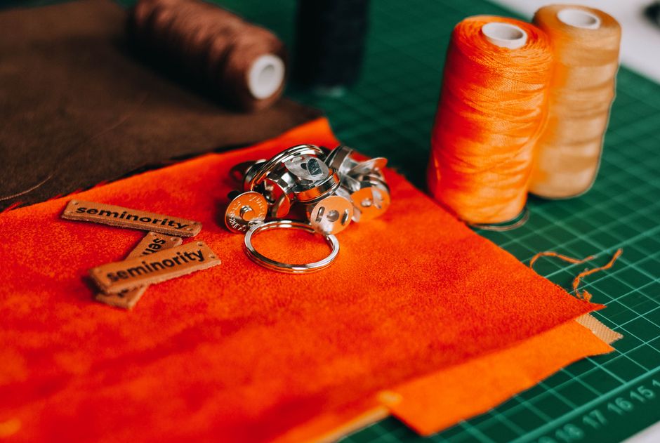 Vibrant sewing supplies including thread and fabric arranged on a cutting mat.