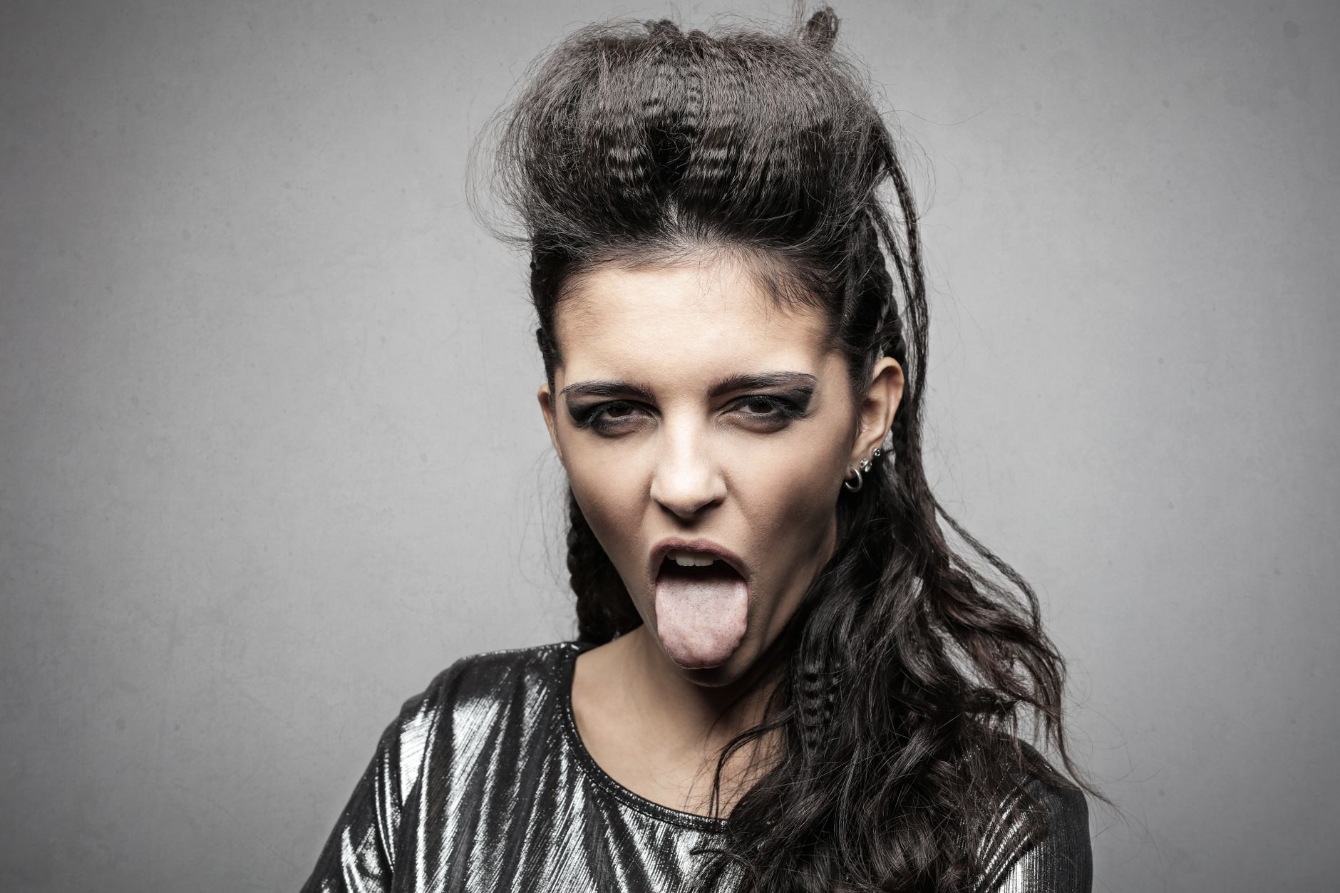 Portrait of a woman with punk hairstyle, sticking her tongue out.