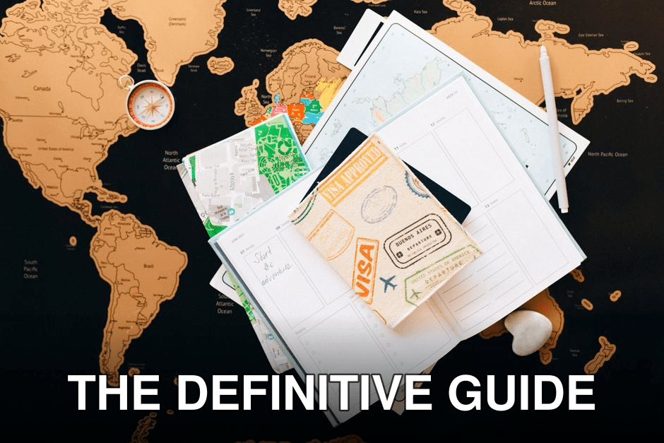 A flat lay of travel planning items on a map, featuring a compass, notebook, and guide for wanderlust enthusiasts.