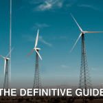 A wind farm with turbines against a clear blue sky in a desert setting.