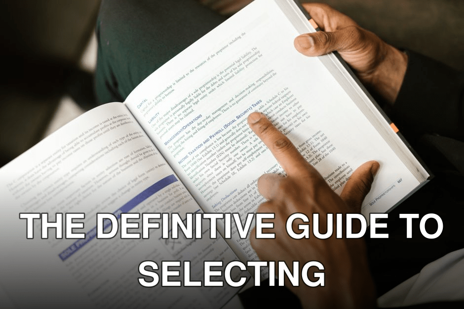 An adult reading a book on taxes, focusing on specific text with a pointing finger.