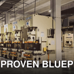 A row of industrial machines on a factory floor, highlighting manufacturing equipment.