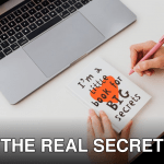 Overhead view of a woman writing in a notebook labeled 'I'm a little book for BIG secrets' beside a laptop.