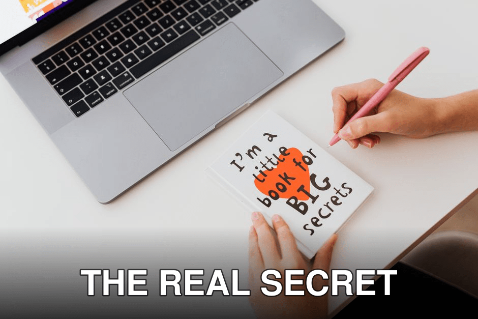 Overhead view of a woman writing in a notebook labeled 'I'm a little book for BIG secrets' beside a laptop.