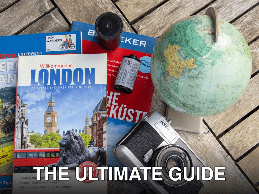 Flat lay featuring London travel guide, vintage camera, and globe, ideal for travel theme.