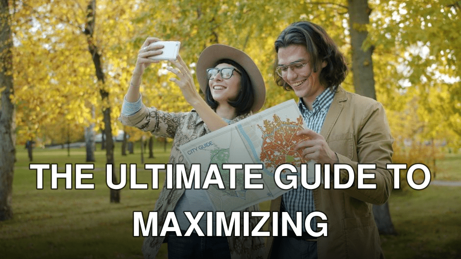 A happy couple using a map and phone in a leafy autumn park.