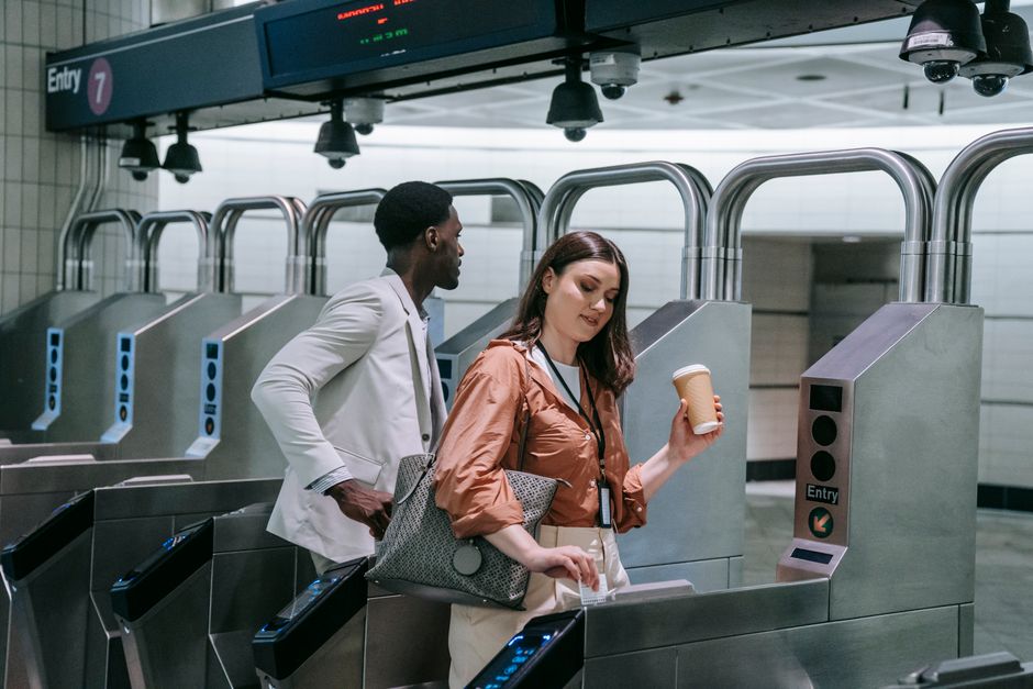 Diverse commuters with coffee entering subway turnstiles, symbolizing urban daily commute.