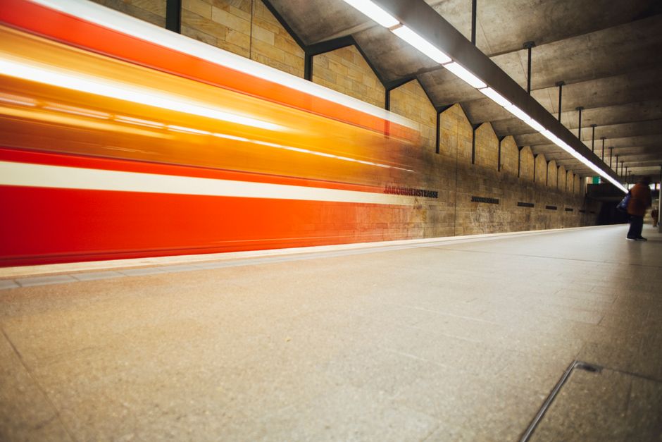 Long exposure of a subway train speeding through an underground station, capturing motion and energy.
