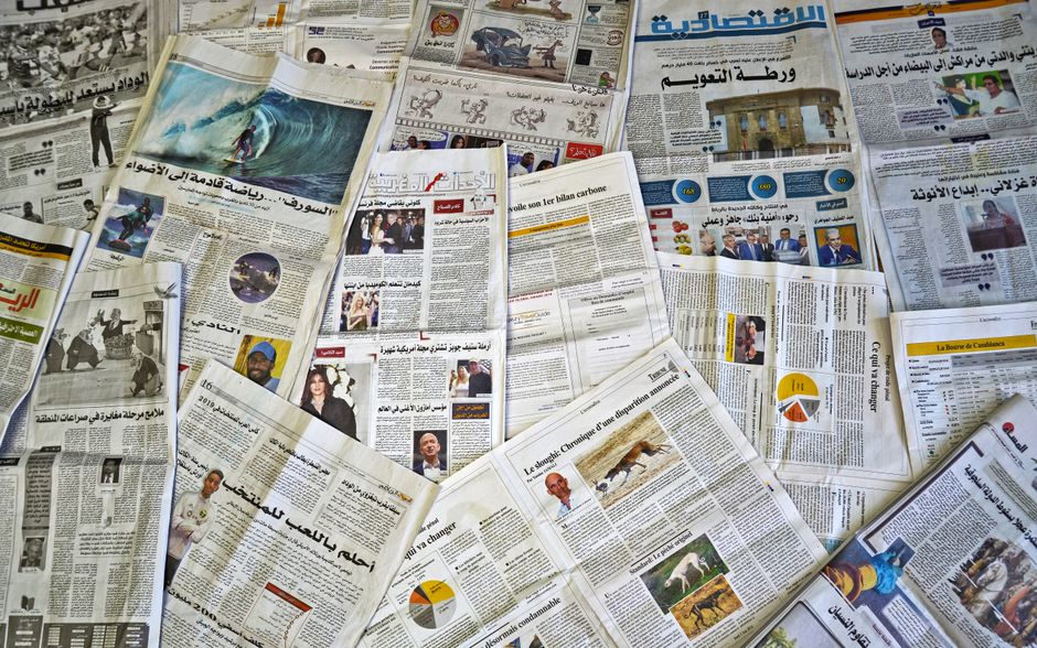 A variety of Arabic newspapers laid out, showcasing cultural and news diversity in Fès, Morocco.