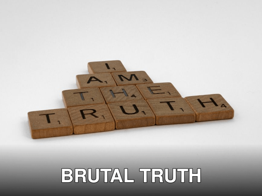 Close-up of wooden Scrabble tiles on a white background spelling 'I Am The Truth'.