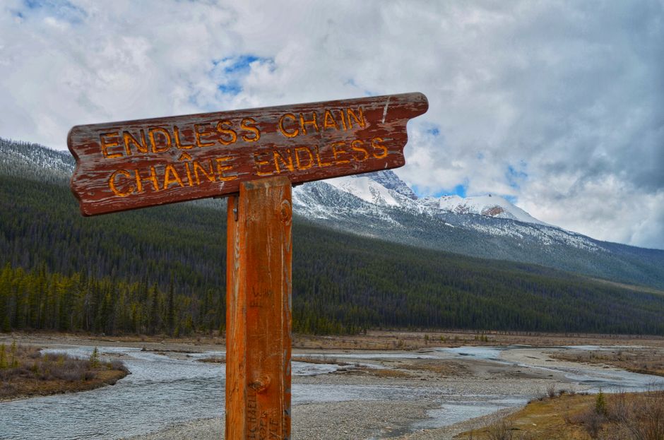 View of a scenic valley with Endless Chain signpost and snow-capped mountains.