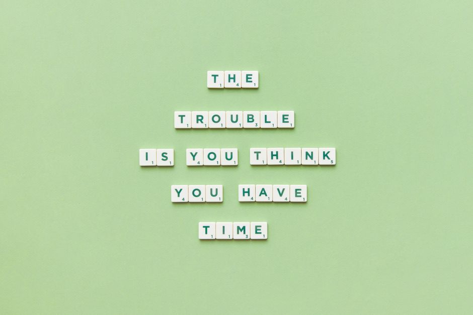 Scrabble tiles arranged to spell a motivational quote against a green background.