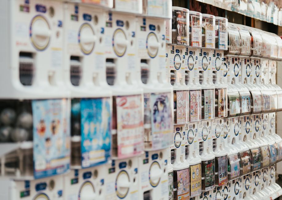 A vibrant row of gachapon vending machines in Japan showcasing a variety of collectible toys.