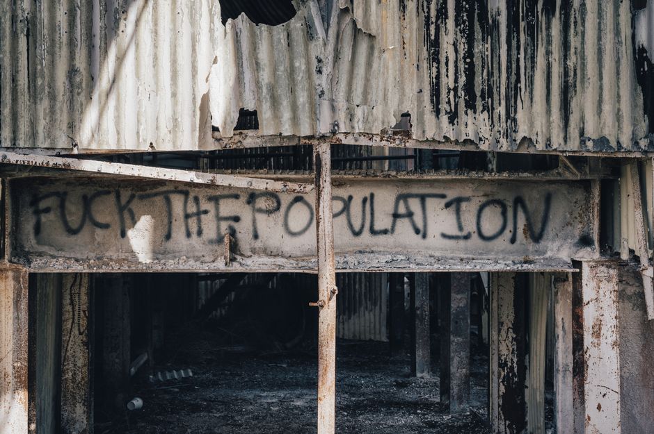 Graffiti on an abandoned, rusty structure conveying urban decay and rebellion.
