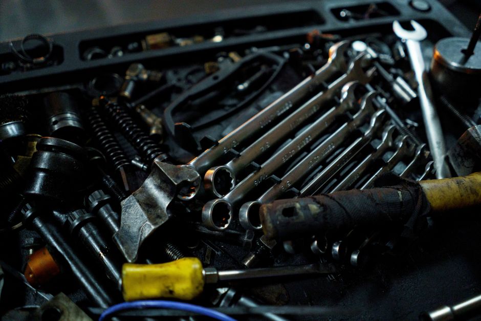 Detailed view of various mechanical tools laid out in a toolbox, ideal for industrial themes.