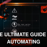 3D printer build plate with warning symbols, showcasing high-tech equipment in a workspace.