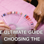 Hands selecting nail polish shades on color palette at salon. Manicure selection process.
